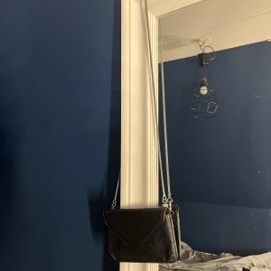 Filippa K väska  - En super söt liten Filippa K väska i nyskick.  Väskan är i svart läder och en fina tunn silver kedja.   Nypris 1000kr nu 500kr 