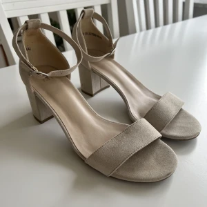 Klackskor Beige  - Beiga klackskor i mockaimitation som endast är använda en gång, därmed är skicket fint!💞 Storlek 38 
