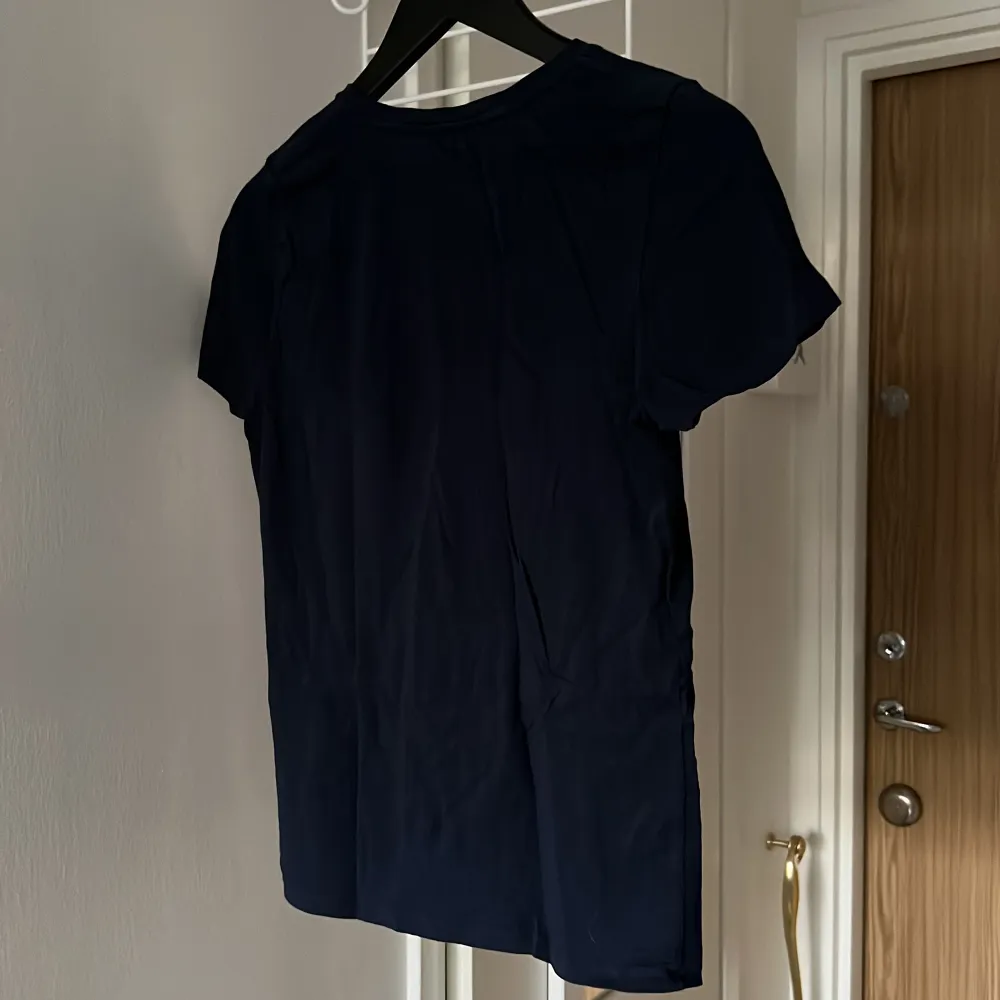 Marinblå t-shirt med tryck från Carin Wester i stl S. Väl använd med i bra skick. Köparen betalar för frakt . T-shirts.