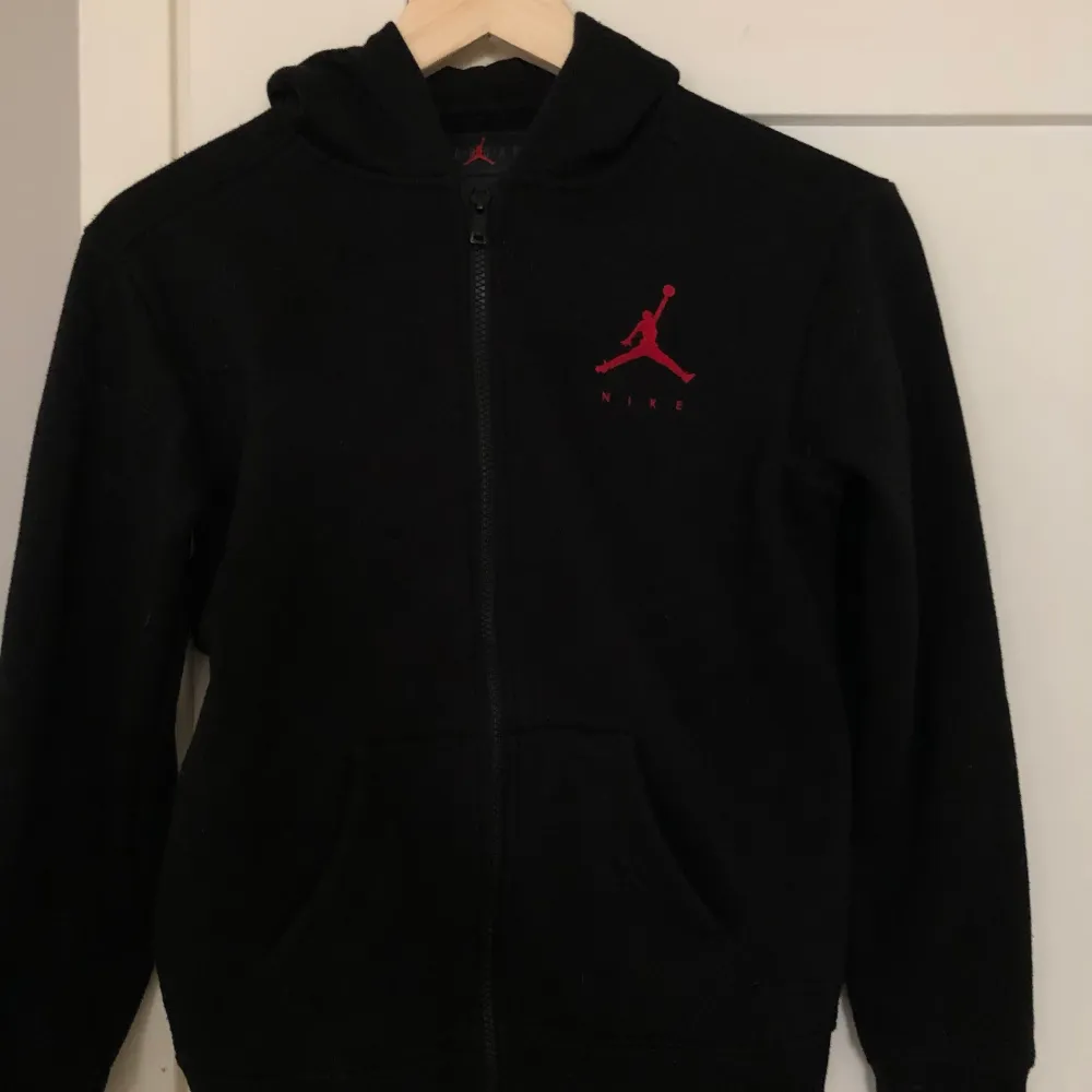 Jordan Nike hoodie med dragkedja, svart med tryck. Stort tryck på ryggen, litet på framsidan. Använd men är i fint skick. Annonsen finns på fler sidor. . Hoodies.