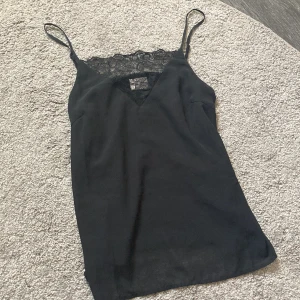 Svart linne stl xs  - Ett svart linne med spets vid bröstet, använd endast några få gånger. Superfin men inte min stil (: