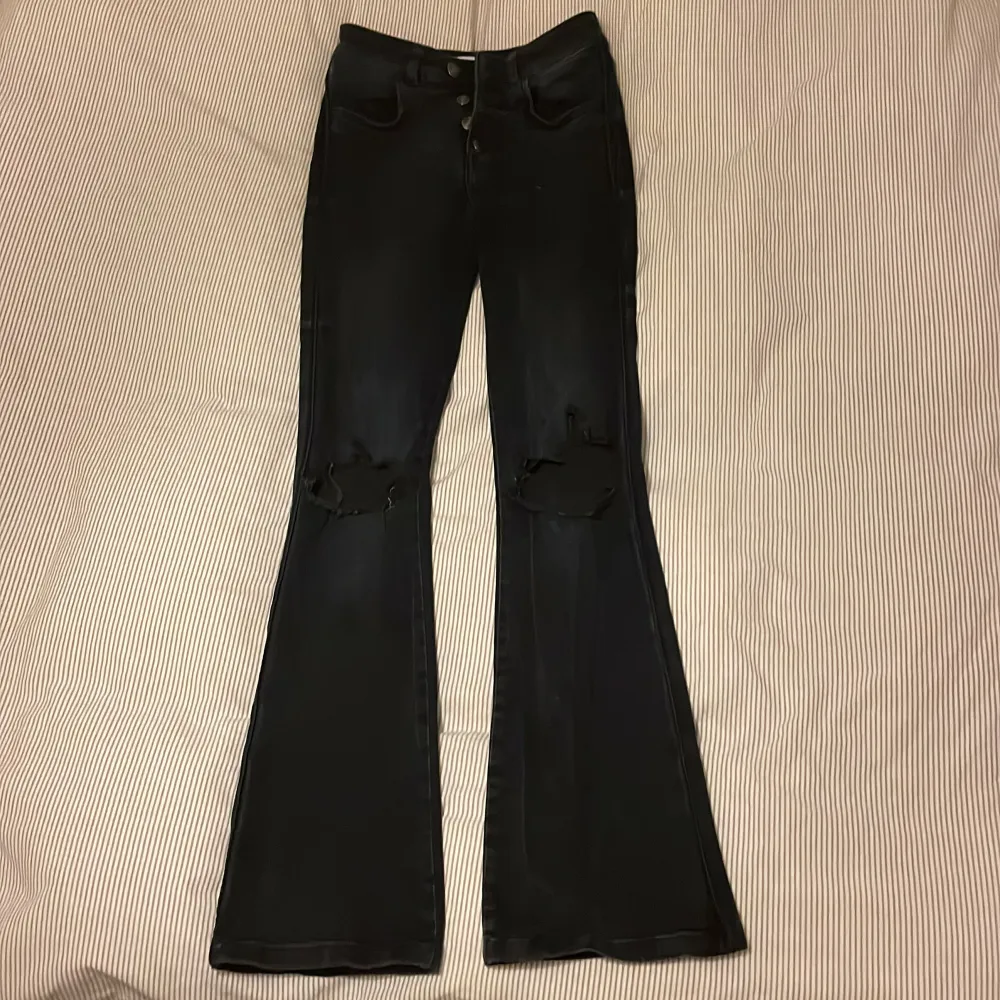 Svarta bootcut jeans med hål på knäna, säljer pga lite för små och kommer ej till användning, storlek xs och jeansen är från Elsa Ekmans kollektion från bikbok, använd endast fåtal gånger, frakt tillkommer alternativt möts upp i Sthlm❤️‍🔥❤️‍🔥. Jeans & Byxor.