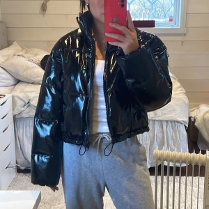 Pufferjacka - Supersnygg svart glansig croppad pufferjacka från H&M i storlek xxs, skulle säga att den passar xxs-s eftersom den är lite större i modellen. Säljer den då den inte kommit till användning. Aldrig använd!