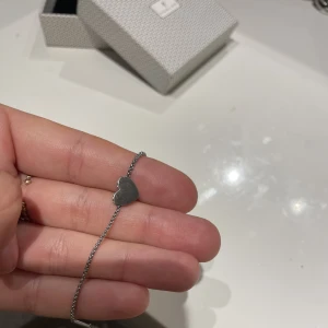 Armband  - Armband i hjärtmotiv från Edblad. Silver med ”diamanter” på sidorna. I mycket bra skick 