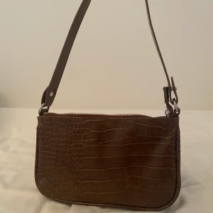 Handvändning  - Brun ormmönstrad väska från kappahl. har en ficka med dragkedja och är lätt att bära runt. pris går att diskutera. köparen står för frakt. 💗