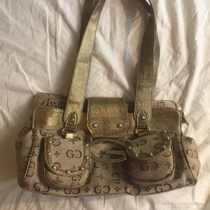 Y2k väska - Säljer nu en av mina favoritväskor då den ej kommer till så mycket användning längre. Köpt här på plick. Har behövt sy fast ena axelbandet då det va trasigt när jag fick väskan (se sista bilden), men ingenting som är särskilt märkbart. Måtten är ca 35x15 