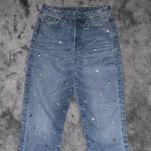 Jeans - Jeans med olika ”smyckes berlocker på”, aldrig använda då de är för korta tyvärr. Fint skick och bra material.