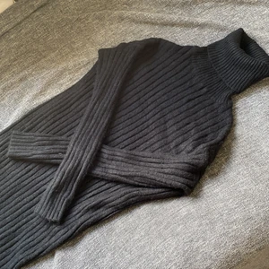 Stickad polokläning Strl M - Lång svart stickad klänning med lång hals, ALDRIG använt då jag inte använder klänningar. Den kommer en liten bit under mina knän då jag är 168. Klänningen är också i storlek M :)