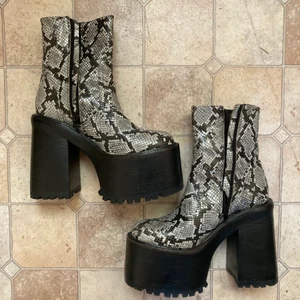 Jeffrey Campbell platåskor svart ormskinn - Ett par supersnygga Jeffrey Campbell platåskor som är jättesköna och bekväma att gå i. St 39. 12 cm klack. Använda en gång pga inte min stil. Nypris 2500 kr. Går att hämtas upp i Sthlm. 