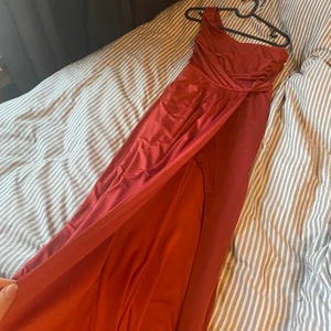 röd balklänning - Lång balklänning, finns en fin slits vid benet, kan Skixka bilder hur den sitter på