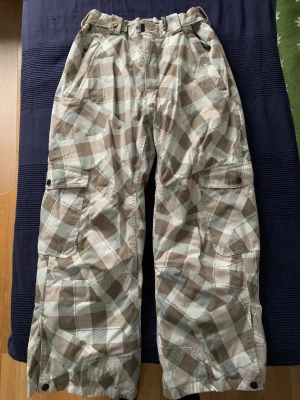 Salomon skidbyxor - Min sambo säljer sina skidbyxor av märket Salomon, vit-beige-rutigt. Använt men bra skick.