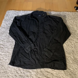 Skjorta svart  - Svart snygg skjorta, gillar passformen. Secondhand, snygg med vit tröja under.