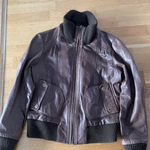 Brun läder jacka - Mammas gamla bruna läder jacka från 2000 väldigt fin färg och 100% riktigt läder obs liten i storleken och köparen står för frakten 