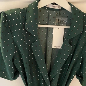 Ny prickig klänning från Mango - Helt ny och oanvänd grön prickig klänning från Mango! Köptes för längesedan så går inte att köpa längre, men har inte kommit till användning då det inte är min stil. Nypris var 799⚡️ Den har knappar och fickor på framsidan, ett band i midjan samt axelvaddar för snygg figur! Superfin!💘