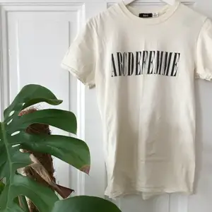 Säljer denna snygga naturvita T-shirt från Urban Outfitters. Gott skick, hel och ren. 100% bomull med trycket ”ABCDEFEMME”. Skriv vid intresse💞