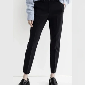 Svarta kostymbyxor - Strl. 36 - Helt oanvända svarta kostymbyxor (slacks) från H&M, prislappen sitter kvar. Obs! Modellen på bilden är 175 cm lång
