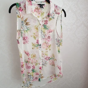 Ärmlös topp stl 36 - Blommig tunn, genomskinlig ärmlös topp från H&M stl 36, funkar som stl 38 också, har aldrig blivit använd.
