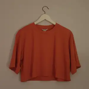 Orange cropped T-shirt från Monki. Ribbat tyg. Helt oanvänd och i storlek medium.