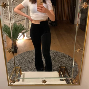 Byxor i sammet  - Svarta byxor med glittrig detalj i midjan. Aldrig använda! Passar S