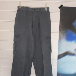 Vintage Dickiesbyxor - Ett par Dickiesbyxor inköpta i vintage butik. Dessa är insydda och passar en S. Längd 32. Högmidjade och vida ben. En söm är påväg att gå upp i midjan men jag tror inte att det är så svårt att sy ihop igen. Skickar gärna bild om du vill se närmare. 