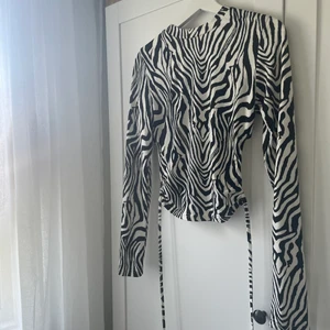 Zebratopp - Supercool zebramönstrad topp med öppen rygg. Väldigt skönt material och tröjan passar perfekt till de mer festliga tillfällena men även till vardags!