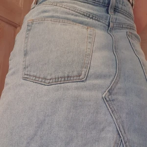 Denim skirt - Superbekväm och hållbar ljusblå denim kjol i bra skick trots att den är väl använd. Använder knappar istället för dragkedja. Jeansmaterialet är i 100% bomull och fickfodret i 66% polyester och 34% bomull. Tvättas i 40°. 