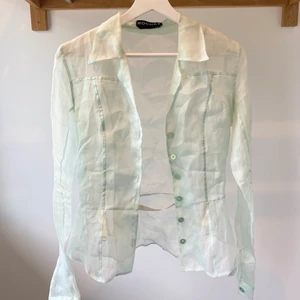 Silkesskjorta  - Säljer min fina, äkta silkesskjorta i mintgrön från Rochas. Köpt vintage. Originalpris 750$. Genomskinligt tyg med resårband och lite korsettliknande passform. I mycket bra skick. Frakt inte inkluderat i priset:) 