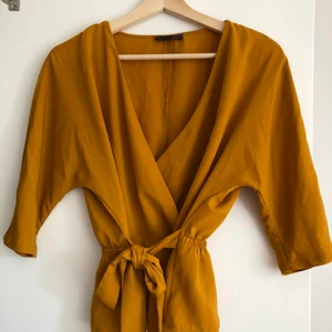 Senapsgul topp - Senapsgul topp med djup urringning och skärp i midjan 