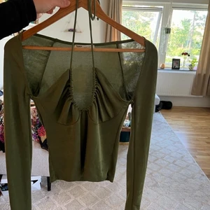 Festtopp - Grön topp i storlek M, passar även en S. Aldrig använd. Material: 92% polyester och 8% elastan. Från Pull and Bear. 