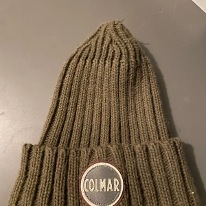 Colmar mössa - Säljer min Colmar mössa då jag kikar på en ny. Perfekt köp inför vintern har en liten lös tråd på toppen, dock  inget som man märker även enkelt att fixa.