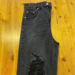 Jeans  - Ett par gråa jeans me hål på båda knäna. Som nya, aldrig använt. För små för mig. 