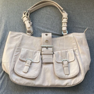 Beige retro väska - Säljer denna jättefina väskan som aldrig riktigt kom till användning, den är inte ny men har dock inte används. Det är skin material på den, skriv privat iaf ni har frågor eller vill ha bilder. 💞(100kr +frakt 66kr) Pris kan diskuteras.❤️