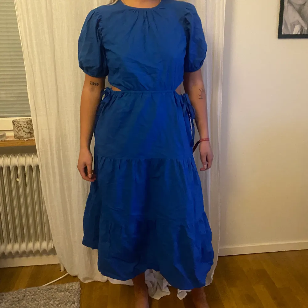 Koboltblå midiklänning med utskurna detaljer i sidan. Nyskick - prislappen kvar . Mekot.