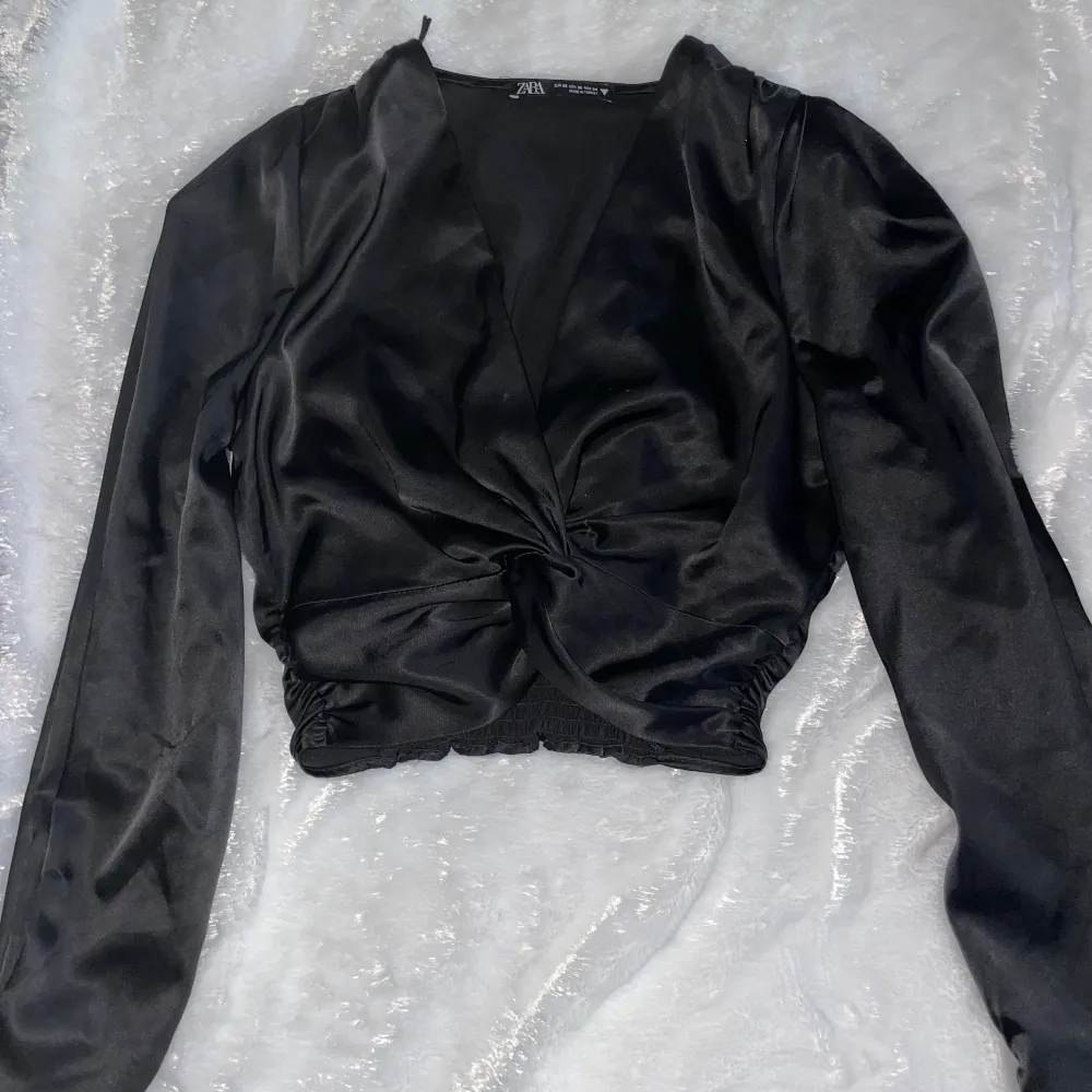 En svart silkes topp från Zara, den sitter väldigt snyggt och har knappar längst ner på ärmarna vilket är en fin detalj, storlek xs.. Toppar.