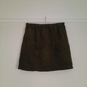 Kjol i manchester - Mossgrön kjol i manchester. Strl XS men passar även S/M pga resår i midjan. Köpt vintage men mycket fint skick.