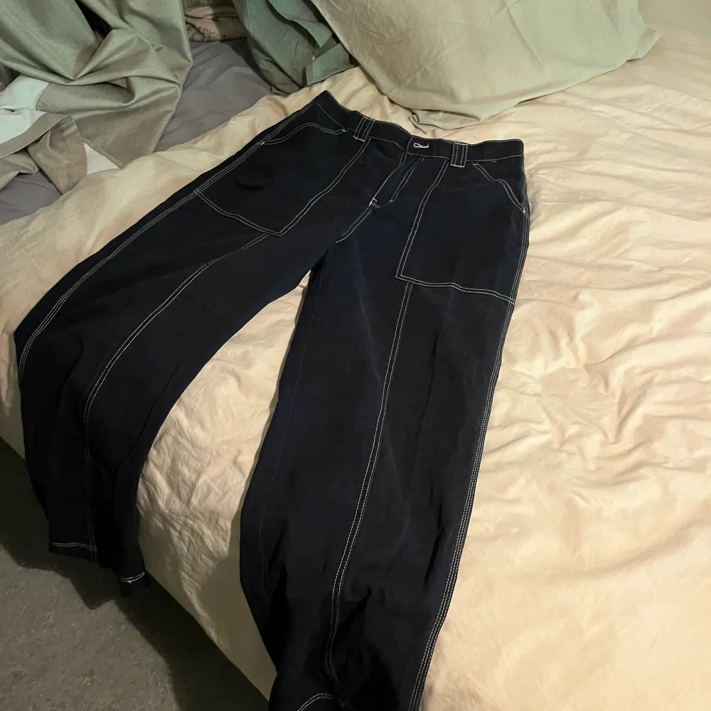 Navyblå byxor med vita streck från weekday. Bra passform, kan passa 38 . Jeans & Byxor.