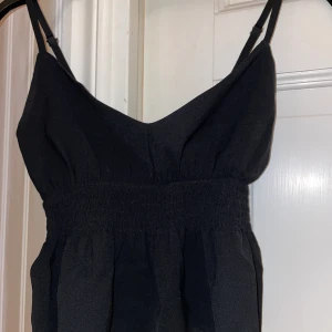 Svart linne - Säljer mitt populära svarta linne i nyskick då jag aldrig har användt den❣️Det går att fixa där bak i banden hur man vill att den ska sitta! Kom privat om du har någon fundering eller vill ha fler bilder!💓