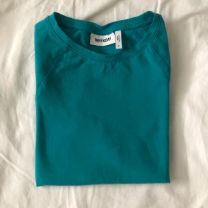 Turkos t-shirt från Weekday - Turkos t-shirt med kort ärm. Använd två gånger och i bra skick. 
