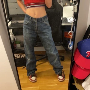 Baggy jeans från beyond retro - Här har vi ett par low waist baggy jeans från beyond retro. Aldrig använda men var köpta med två hål i. Säljer på g av att dem aldrig kommer till anvönding. Skriv om ni vill ha mer bilder eller har några frågor. Köparen står för frakt. W 34 L 30