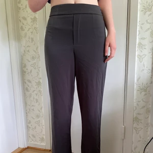 Kostymbyxor i grått - Kostymbyxor i skönt tunt material från BikBok. Byxorna har storlek 38 och säljer för 50kr + frakt!