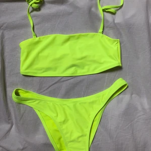 Neongul bikini set - Neongula (super neon) bikini sett, aldrig använd. Båda delarna är i strl M. Axelbanden är avtagbara.