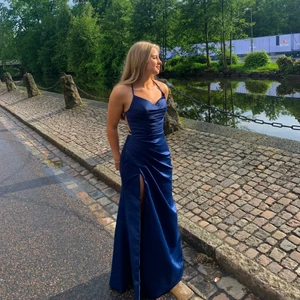 Balklänning marinblå  - Säljer nu min magiska balklänning från ”JJ’S HOUSE”. Det marinblåa tyget är i silke och är mycket rörligt, den har snörning i ryggen, slits på vänstersida ben, gömd dragkedja vid midjan. Inga defekter, använd endast 2 gånger. ❤️💕💖💋❣️