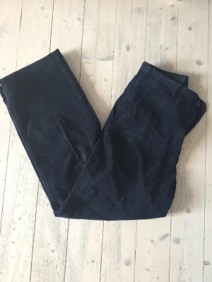 Uniqlo byxor - Fina mörkblå Manchester byxor från uniqlo. Sparsamt använda och bra skick. Säljer p.g.a. för korta för mig, som är 178 cm lång. Midje mått:77 cm. Innerbens  mått: 71 cm. Du står för frakt!