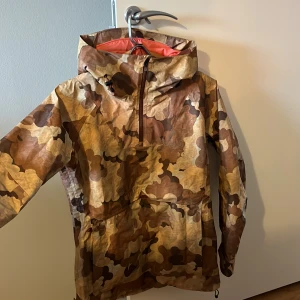 Burton skaljacka dam i gortex - En mycket bra skaljacka i Gortex (vattentät) från märket Burton i ”pullover” stil. Använd en gång och funkade perfekt. Svarar gärna på frågor om detaljer/fickor/luva etc. Köptes för över 2000kr 