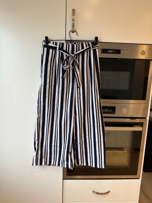 Culotte byxor  - Blå svart randig culottebyxor. Har fickor på sidorna.  Oanvända med etikett kvar.   Storlek 36.