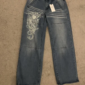 Jeans med tryck - Jeans med vitt tryck från EMMIOL. Oanvända. Säljer dem för att de är för små, små i storlek. Nypris 600kr. 