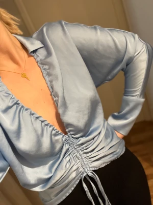 Blus, ginatricot - Helt ny blus (prislapp kavar). Behöver ett nytt hem där den kommer till andväning. Går att ändra i banden hur lång/kort man vill ha den. 