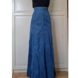 Lång Jeanskjol - Lång högmidjad jeanskjol. Går ner till marken för mig som är 1.67,  så behövs klackar i så fall. Jättefin men för lång och tajt i midjan för mig. Midjemått ca 60cm i omkrets.