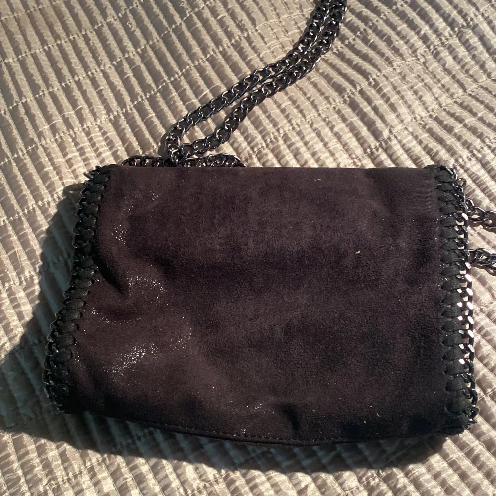 Säljer nu min svarta väska som liknar en tiamo väska (men är inte det). Jag säljer denna för jag inte använder den alls längre. Jag fick den för ett år sedan så jag skulle säga att den är i bra skick (inget har gått sönder)! En svart väska med kedja! . Väskor.