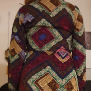 Klänning - Oanvänd. Knappar framtill med Midjeknytband. Mått, längd 105, axlar 42, ärm 60, midja 85.